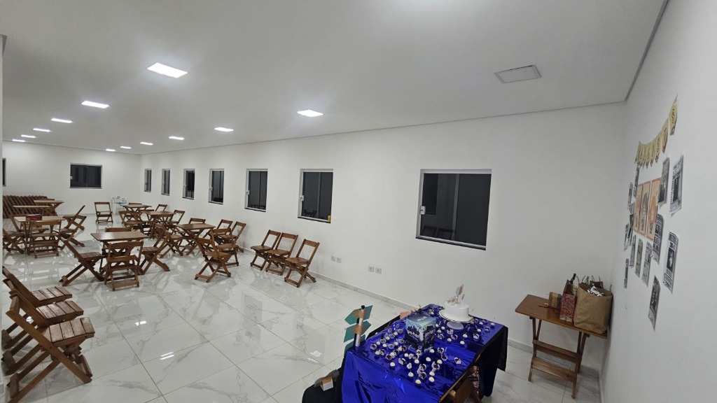 Ambiente de festas do Song Fest, com mesas e cadeiras de madeira e espaço para decoração